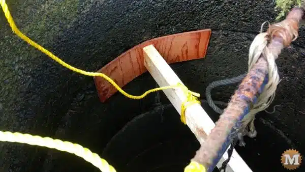 Thin plywood attached to 2x4 wedged into well