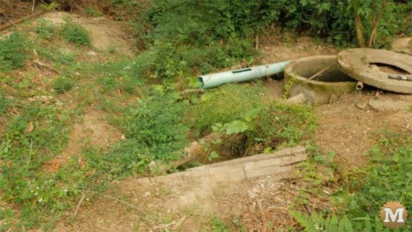 man about tools remove silt mud sediment from well Stream ran right up against casing previous year(s)
