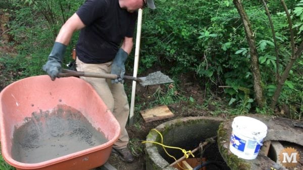 man about tools remove silt mud sediment from well Patching Hole with Cement from the outside