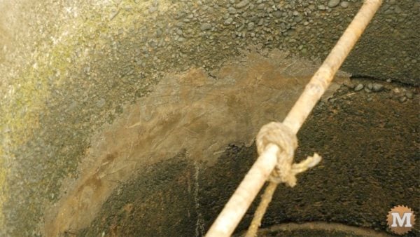 man about tools remove silt mud sediment from well Hydraulic Cement Mortar Patch on inside of well casing
