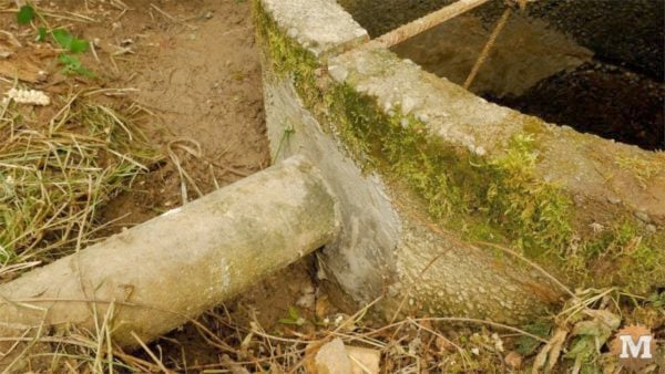 man about tools remove silt mud sediment from well Gap where pipe penetrates well also patched