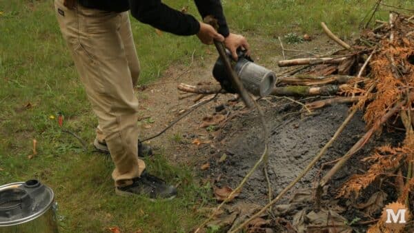 Gently tapping the filters with a stick to clean off ash and creosote Gently tapping the filters with a stick to clean off ash and creosote