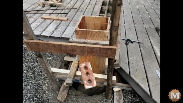 Bricks hang from each end of the strings to keep lines tight Bricks hang from each end of the strings to keep lines tight