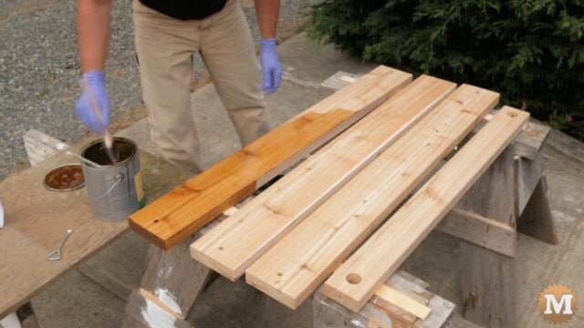 Staining the red cedar of the Garden Bench