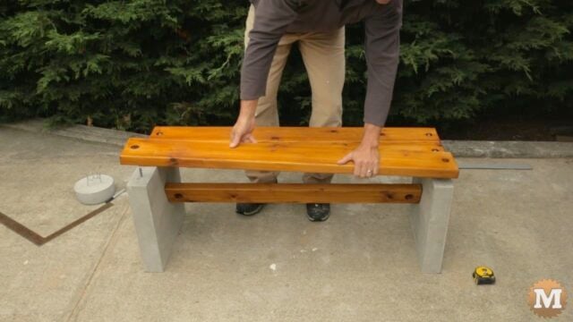 setting the seat slats onto the carriage bolts cast in the concrete legs