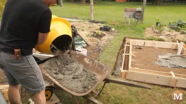 pouring concrete with a mixer into the forms