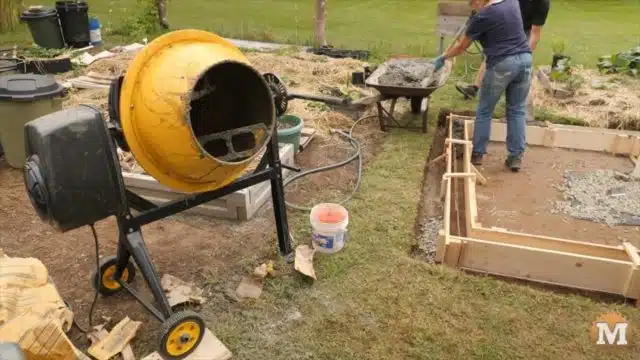 pouring concrete with a mixer into the forms