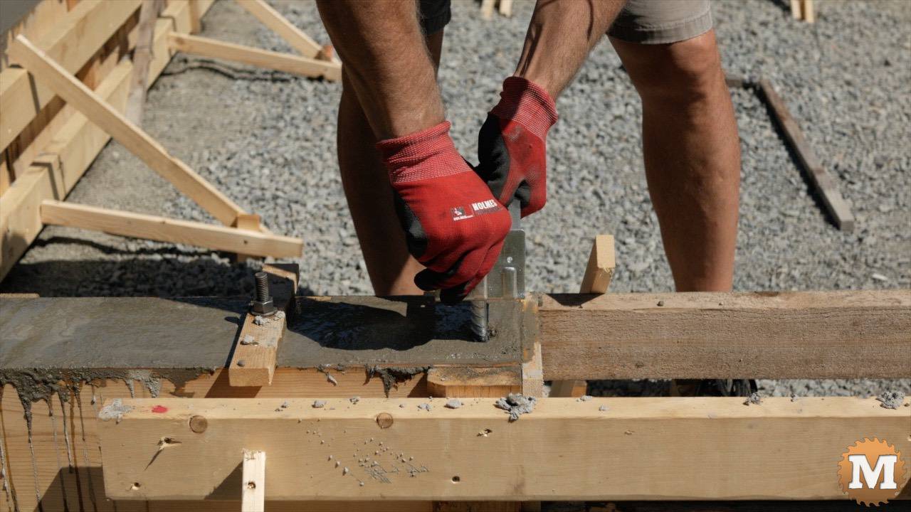 setting a 4x4 galvanized post saddle into wet concrete