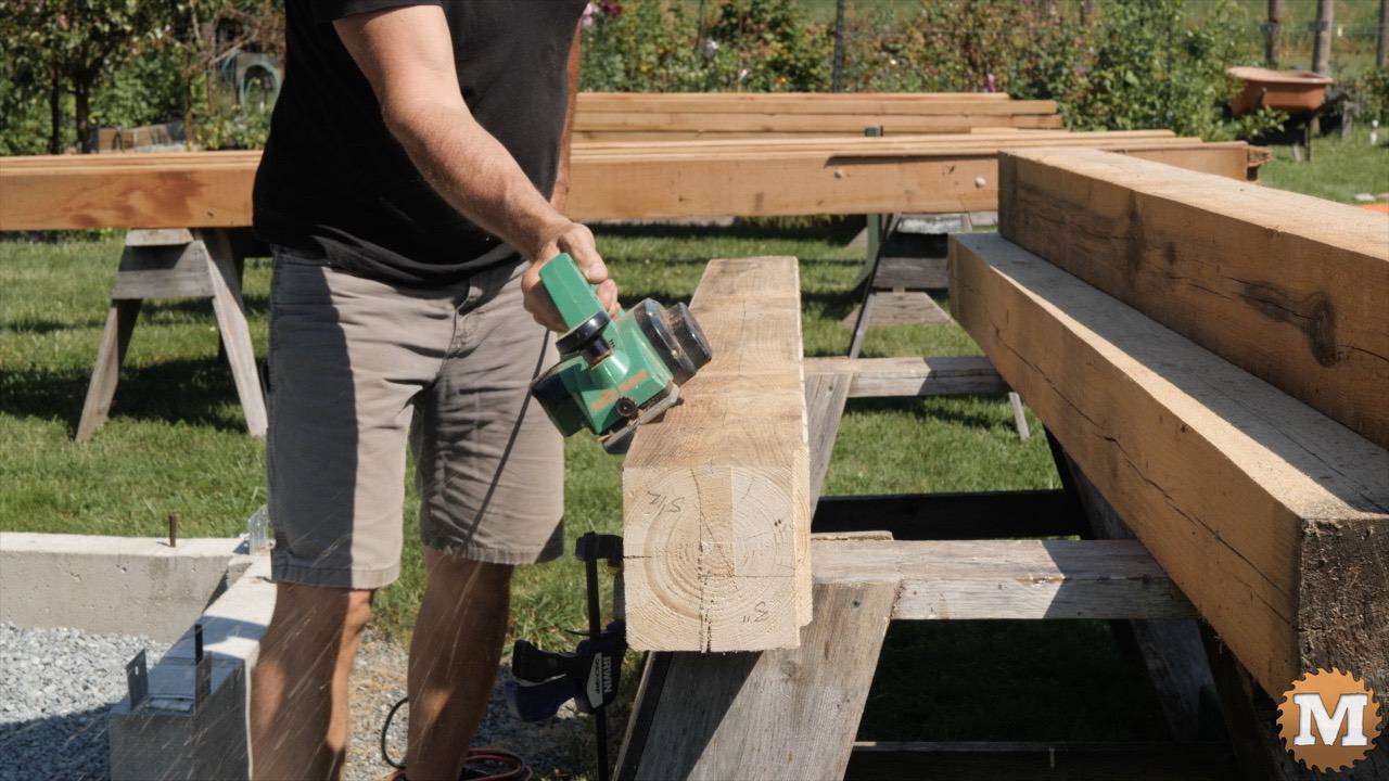 A power plane chamfers the corners of a greenhouse fir post