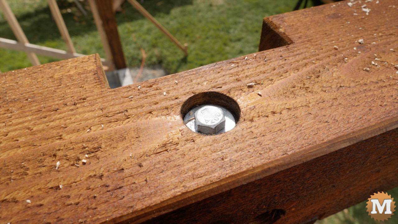 Head of a lag bolt holding a cedar beam to a fir post