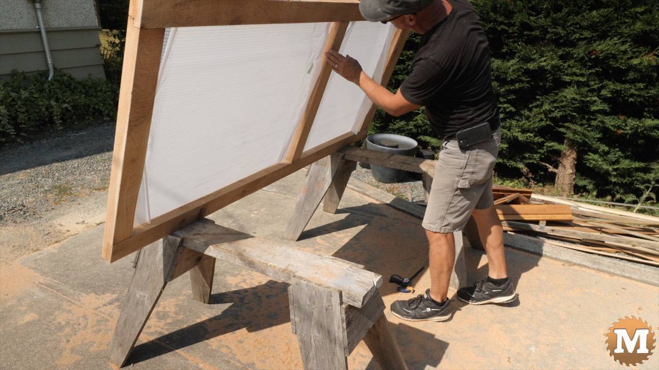 A cedar greenhouse door with plastic glazing panels