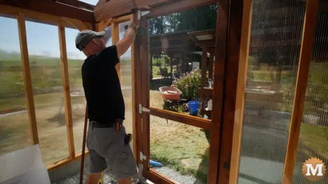 Installing a cedar door in a greenhouse with galvanized hinges