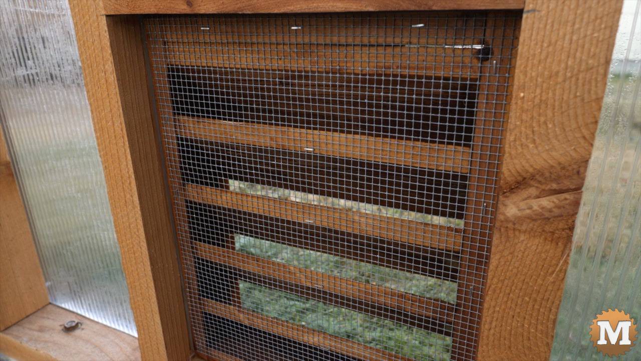 Hardware cloth stapled to inside of greenhouse vent
