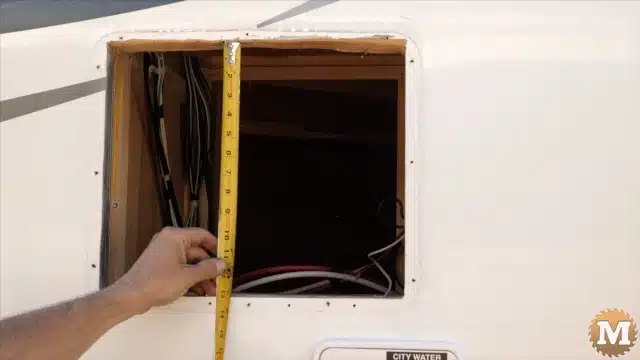 Measuring the existing hole from the battery box location in the side of the truck camper