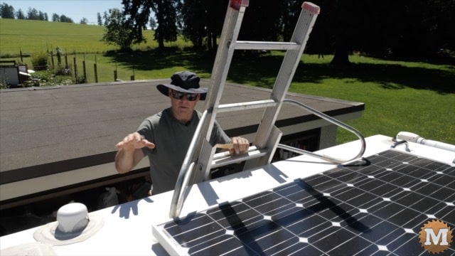 Kent up on the ladder, talking solar panels and such