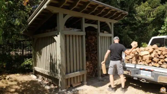 stacking firewood in a larger woodshed