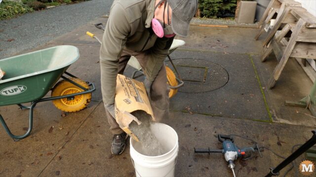 adding concrete mix to a pail