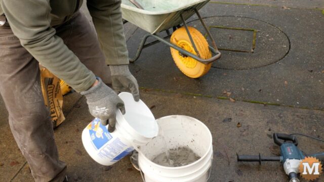 adding cold water to a pail of concrete mix