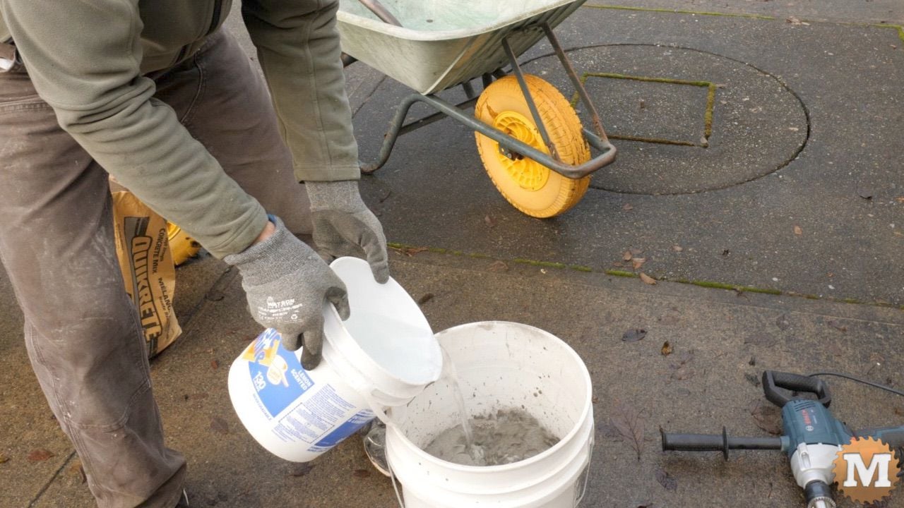 adding cold water to a pail of concrete mix