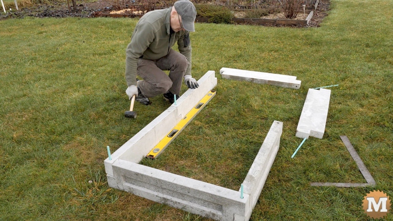 lining up the side wall of the garden bed with a level for reference
