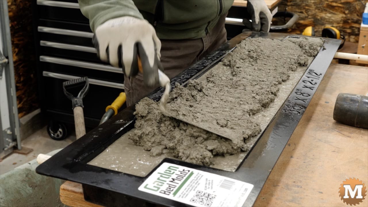 topping up the form with more wet concrete mix