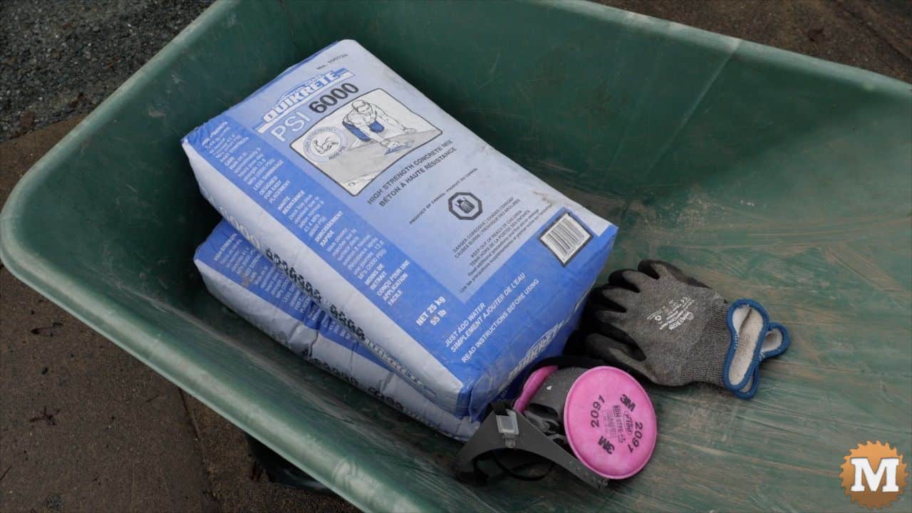 high strength concrete, gloves, and a respirator in a wheelbarrow