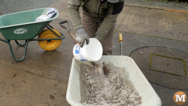 adding cold water to concrete mix in a wheelbarrow
