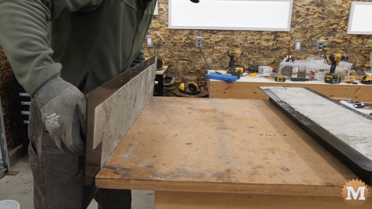 rotating the loaded mold over on the bench while maintaining contact with the edge