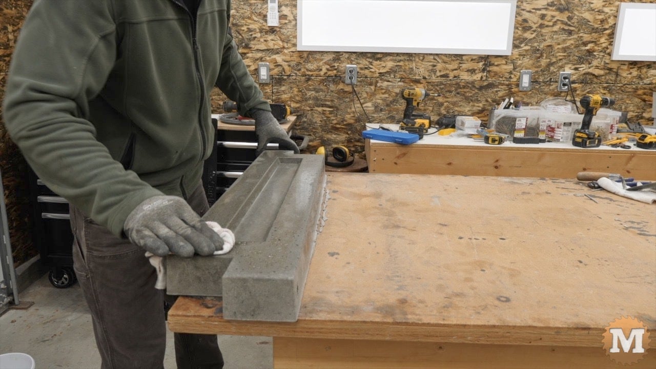 wiping any excess oil from the fresh concrete casting