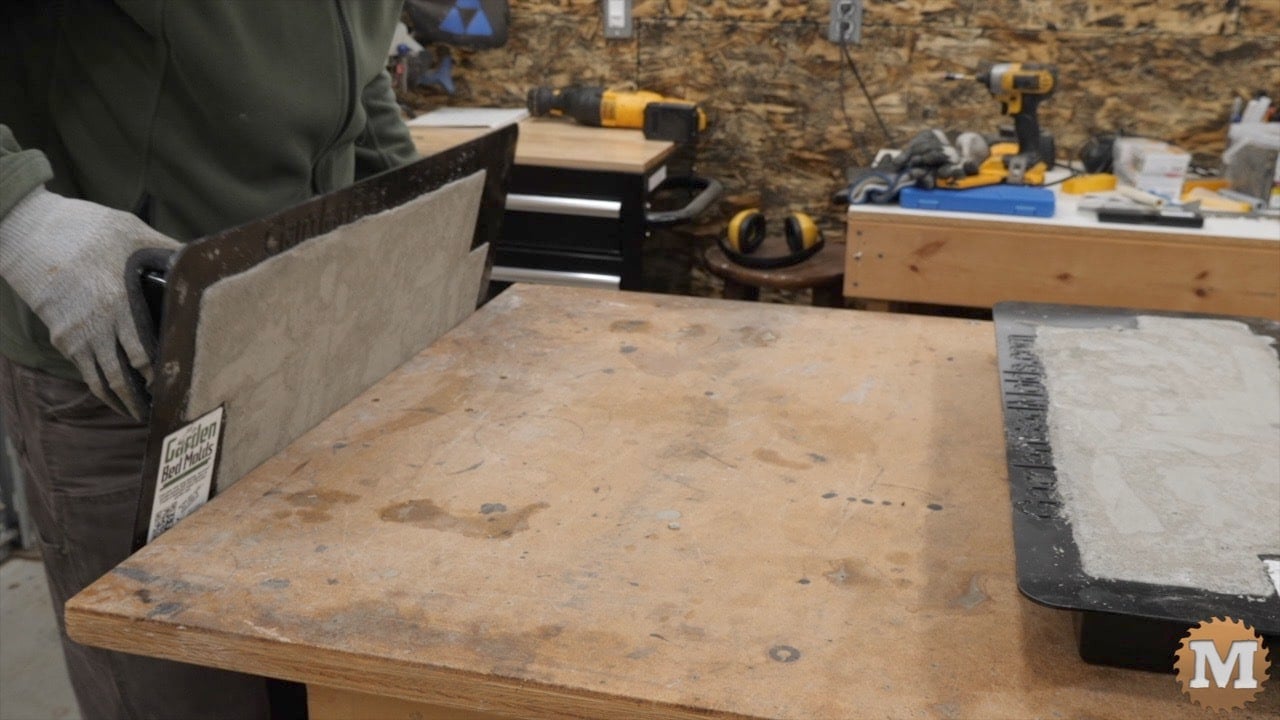 rotating the loaded plastic mold while maintaining contact with the work bench