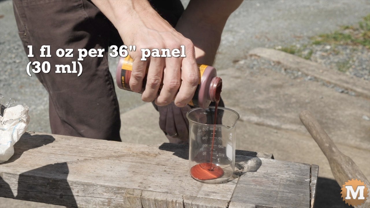 Pouring red concrete dye into a beaker