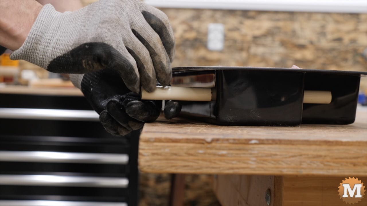 a hand inserting a nail into a pipe