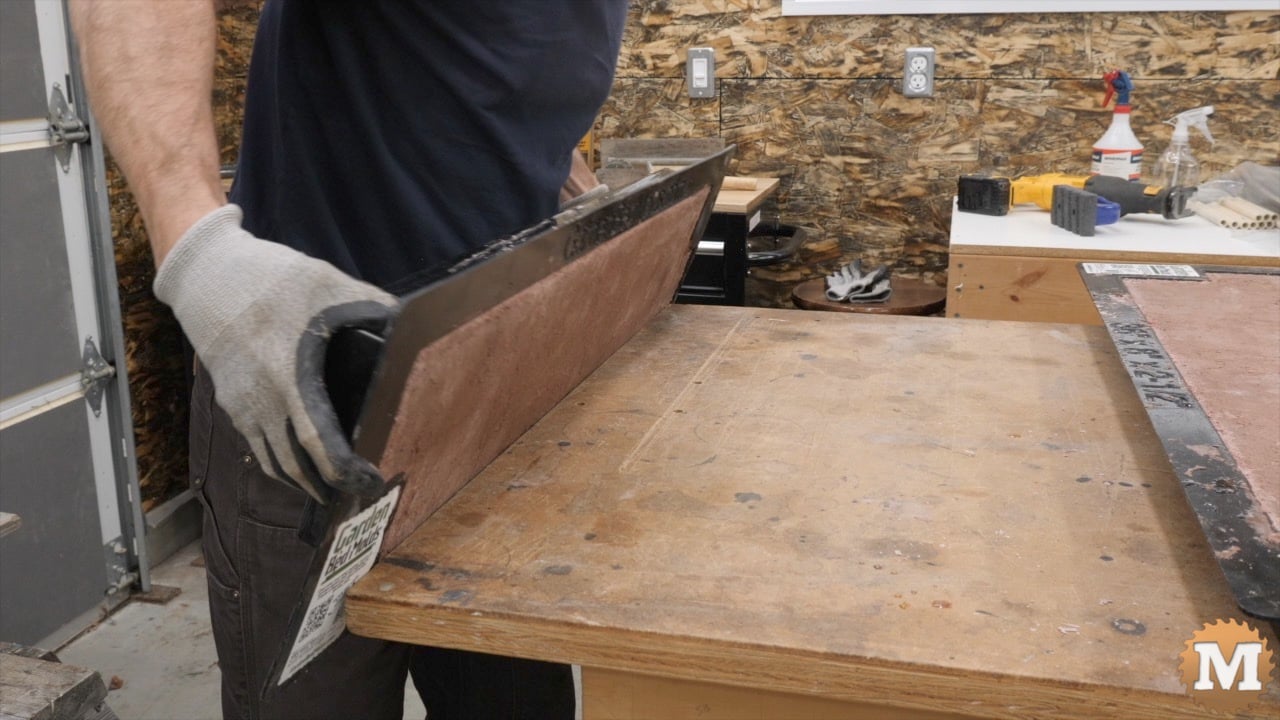 A man turning a mold over onto a bench