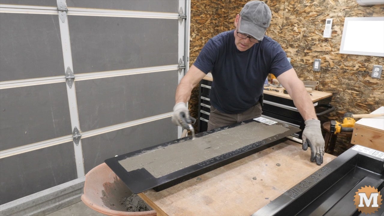 a man troweling wet concrete in a form