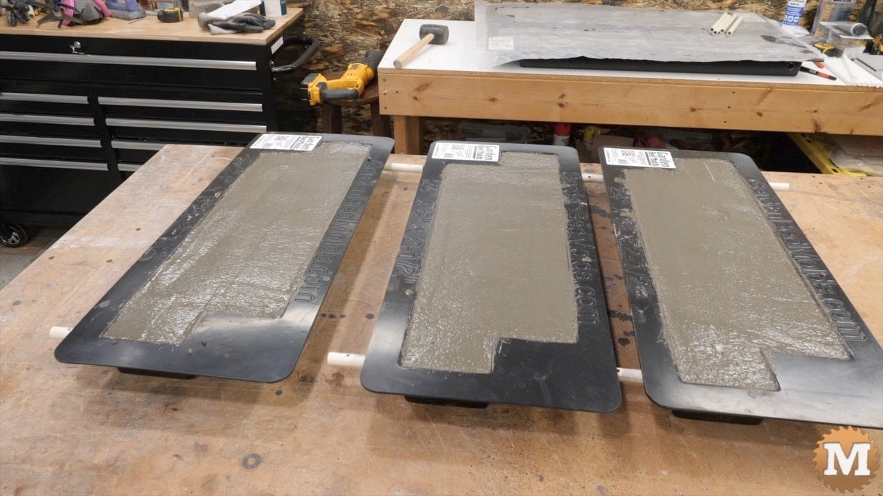 Three concrete forms fill with lightweight concrete on a bench