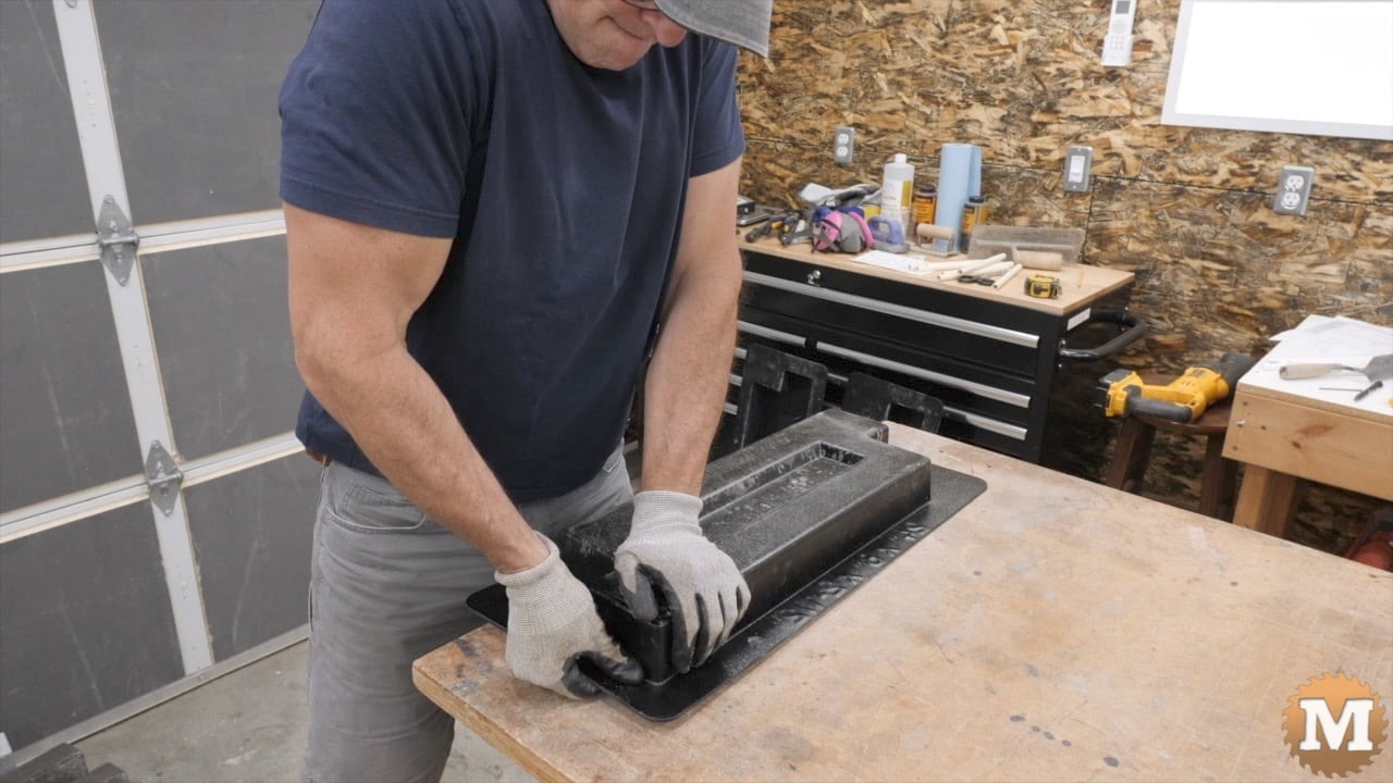 a man working with a plastic mold on a workbench