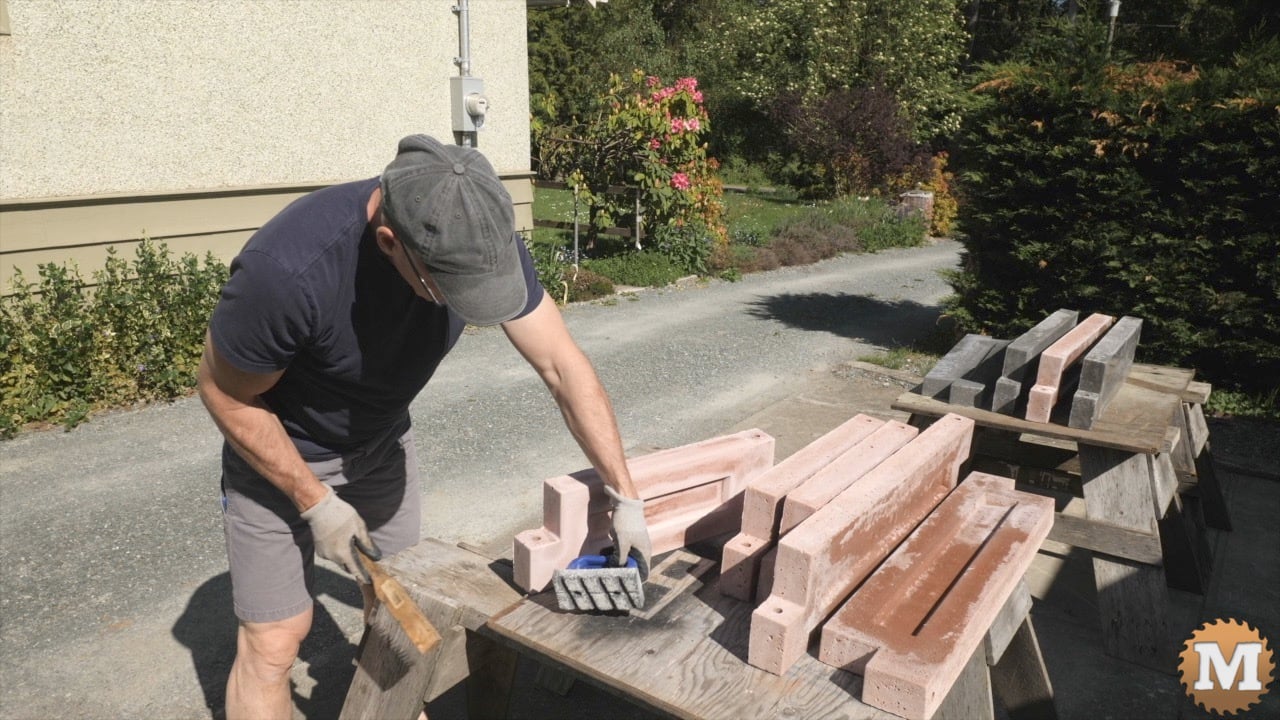 a man cleaning a concrete polishing tool using a wire brush