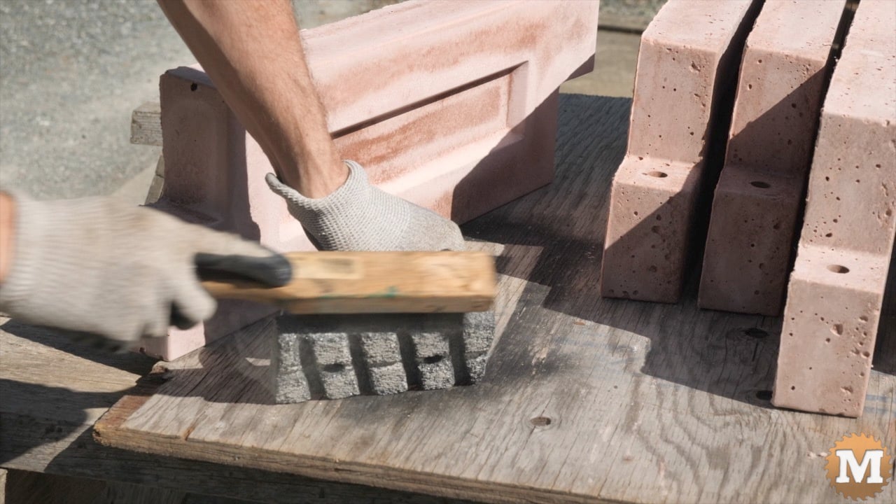 a man cleaning a concrete polishing tool using a wire brush