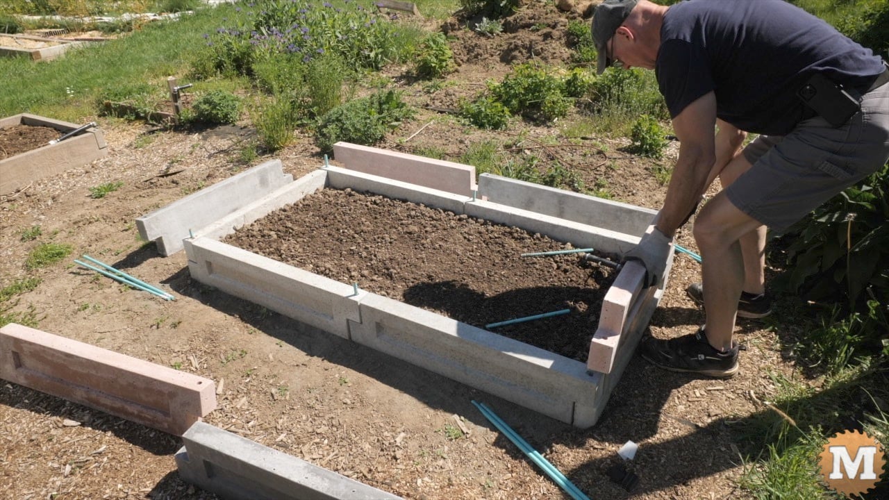 assembling concrete panels into a raised garden bed