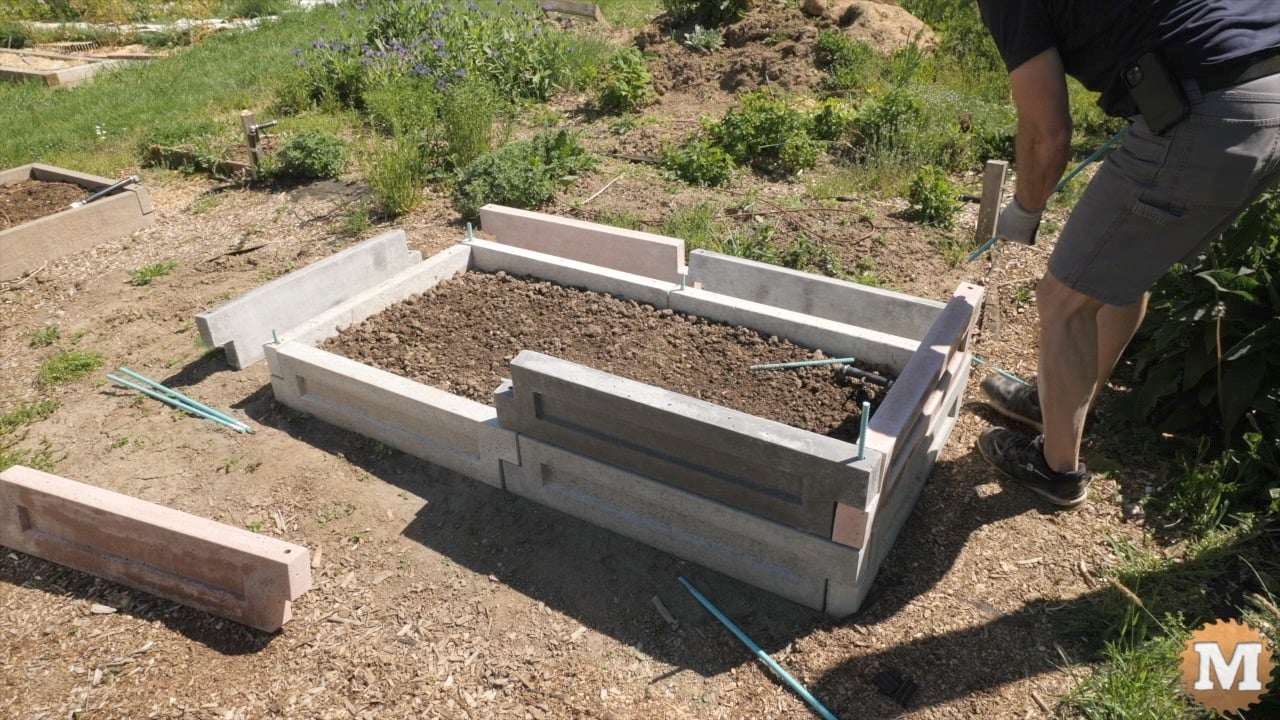 assembling concrete panels into a raised garden bed