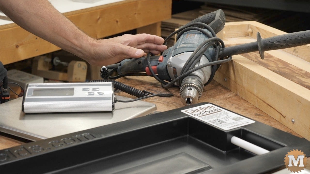 a drill, digital scale, and plastic concrete mold