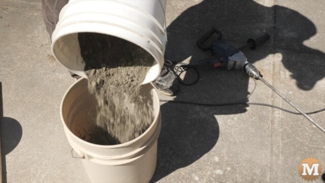 pouring dry concrete mix into a pail