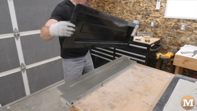 a man holding a plastic mold over a concrete casting