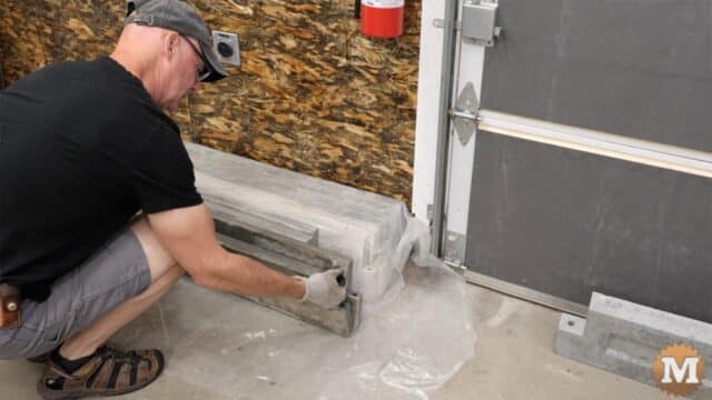 a man setting a concrete casting on a workshop floor