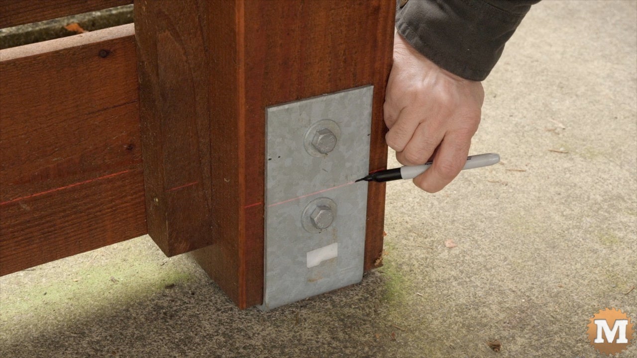 A man marks a post saddle with sharpie