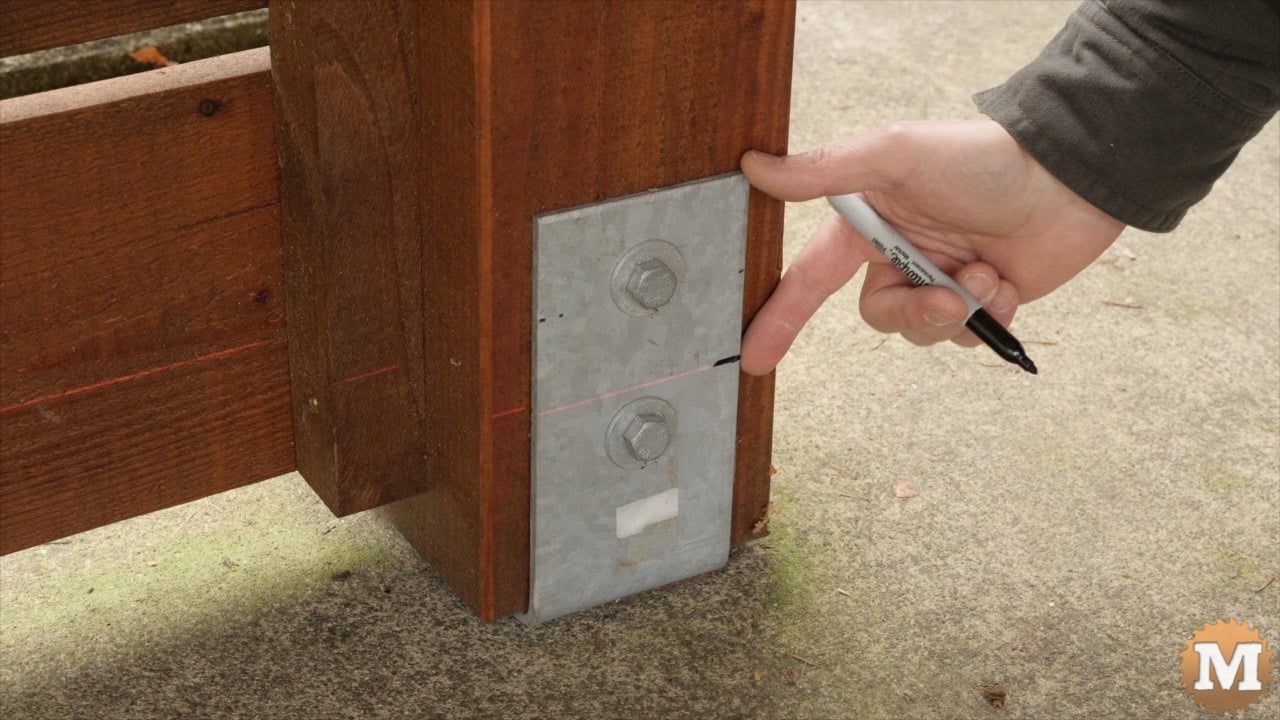A man marks a post saddle with sharpie