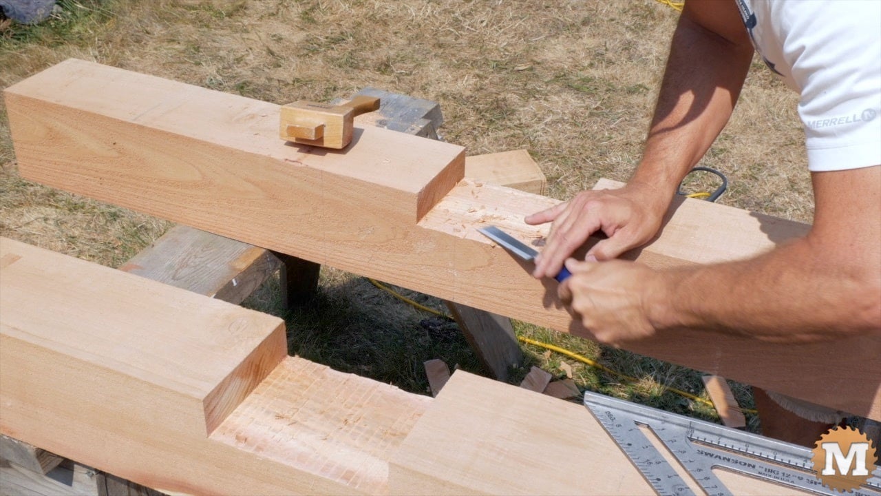 A man using a chisel on a cedar 6x6