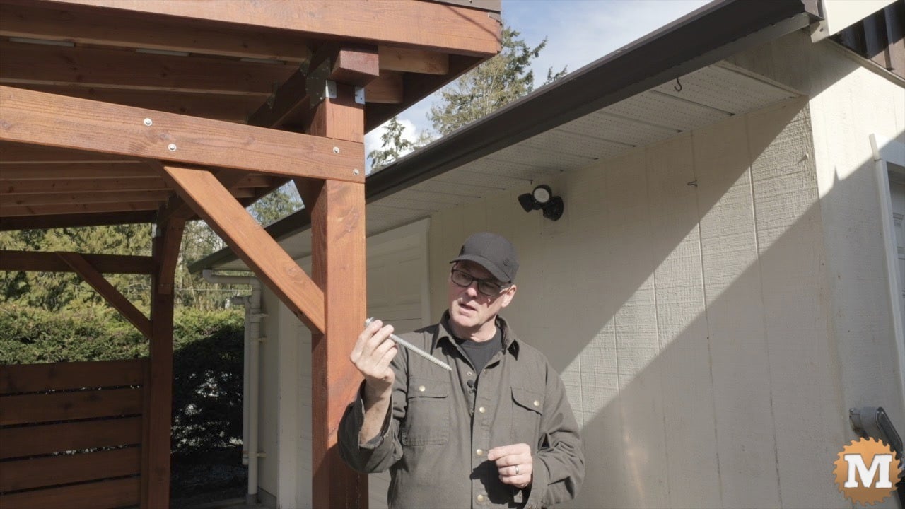 A man holding a long lag bolt