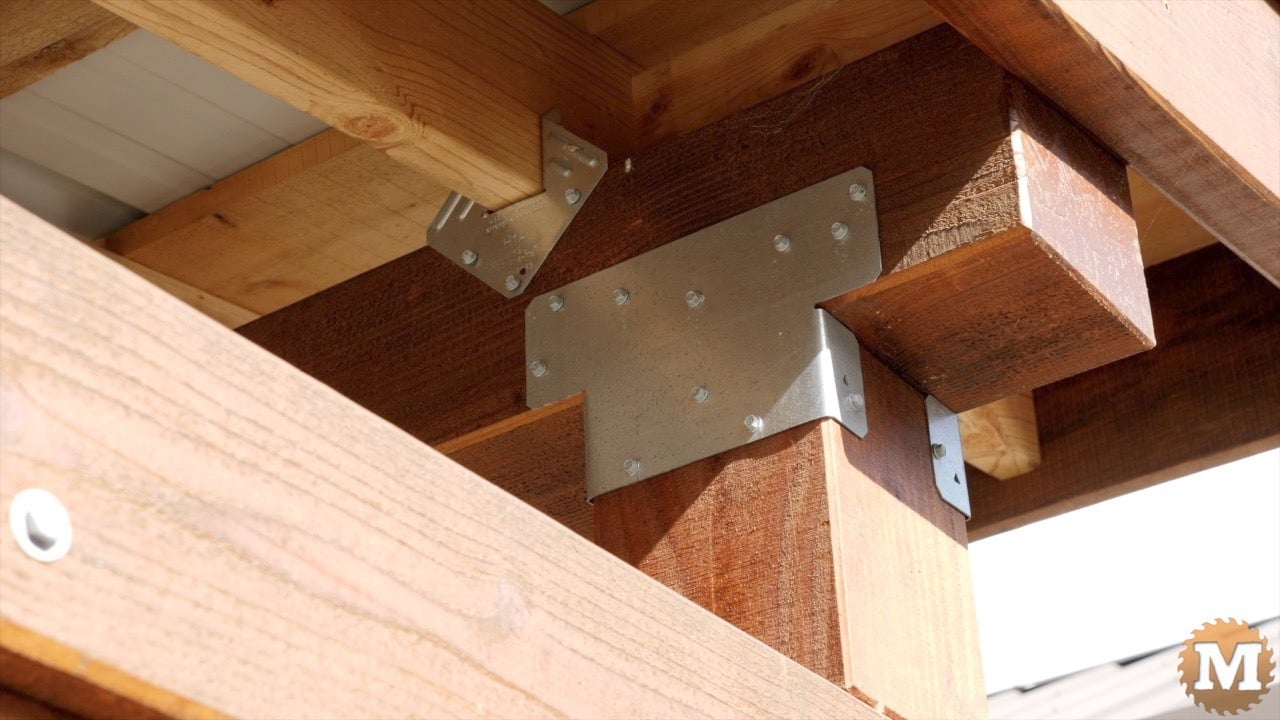 Metal hardware connecting a wooden post to a beam