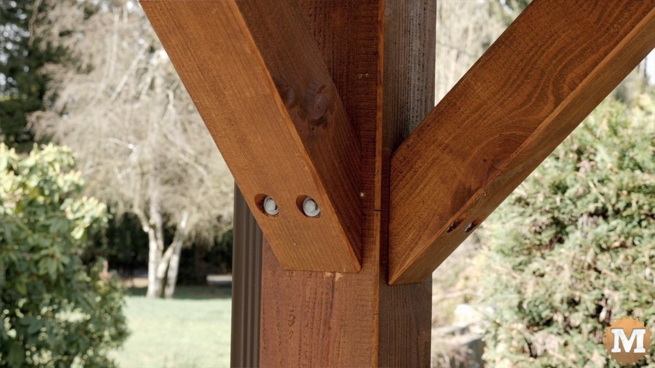 Corner braces attached to a post with lag screws